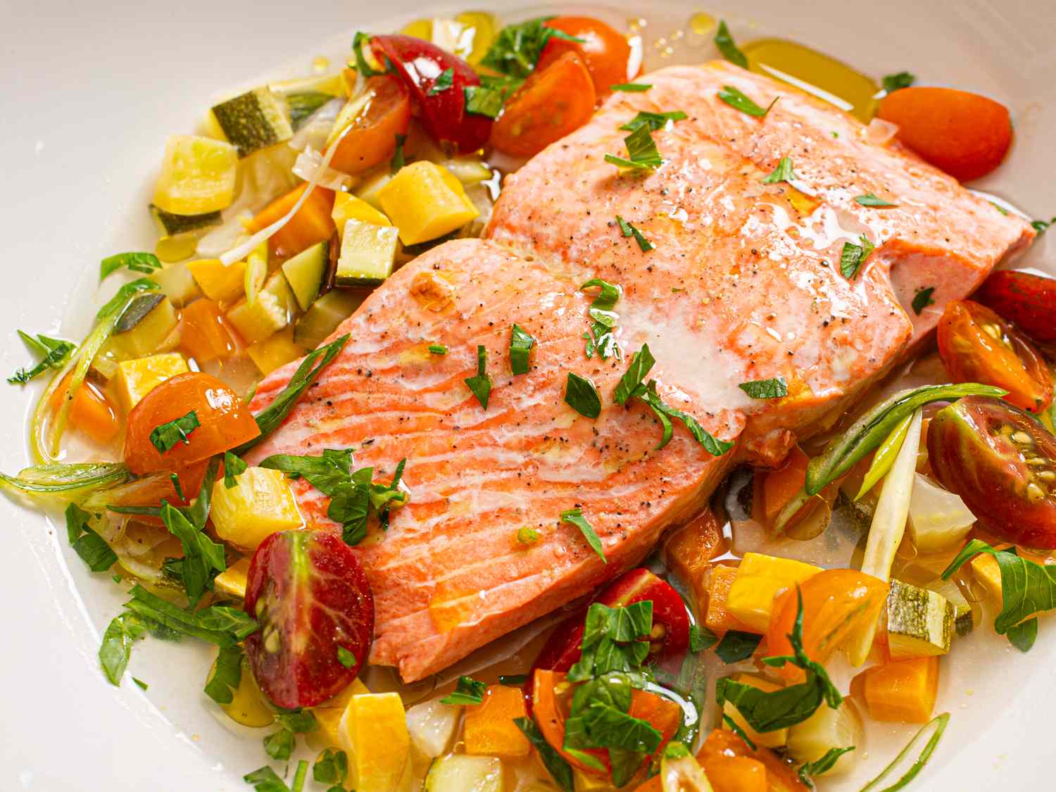 Cooked salmon filet served with diced vegetables and herbs