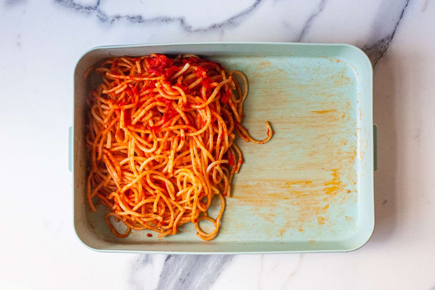 a portion of spaghetti with red sauce in a bento box