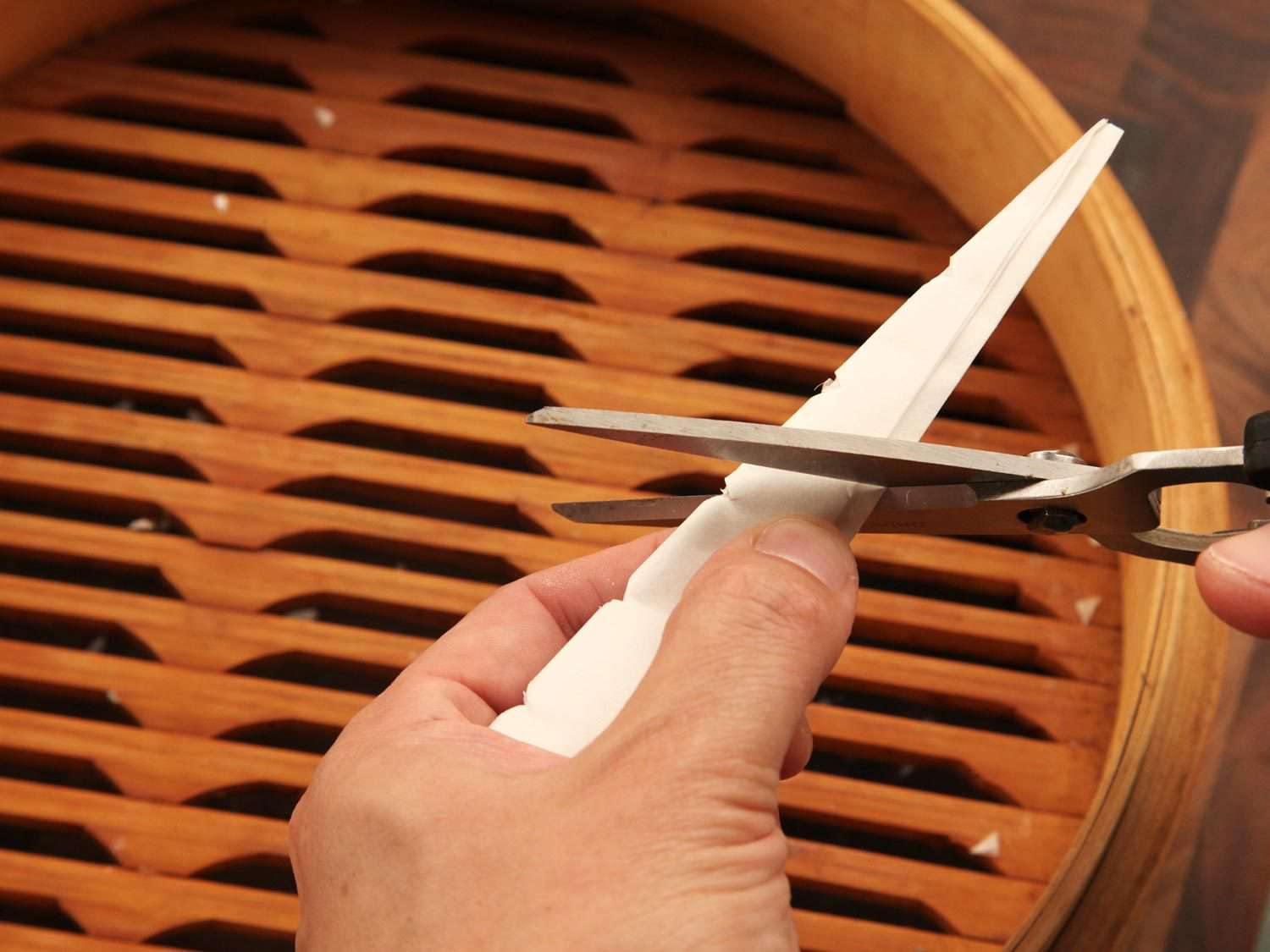 Cutting ridges into a triangle of parchment paper to make vents.