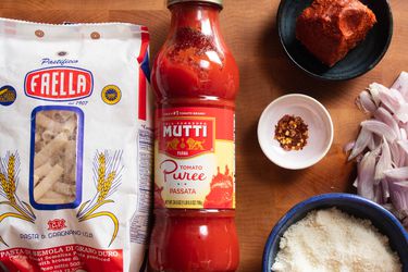 Overhead view of jar of passata, a bag of pasta, and mise en place ingredients.