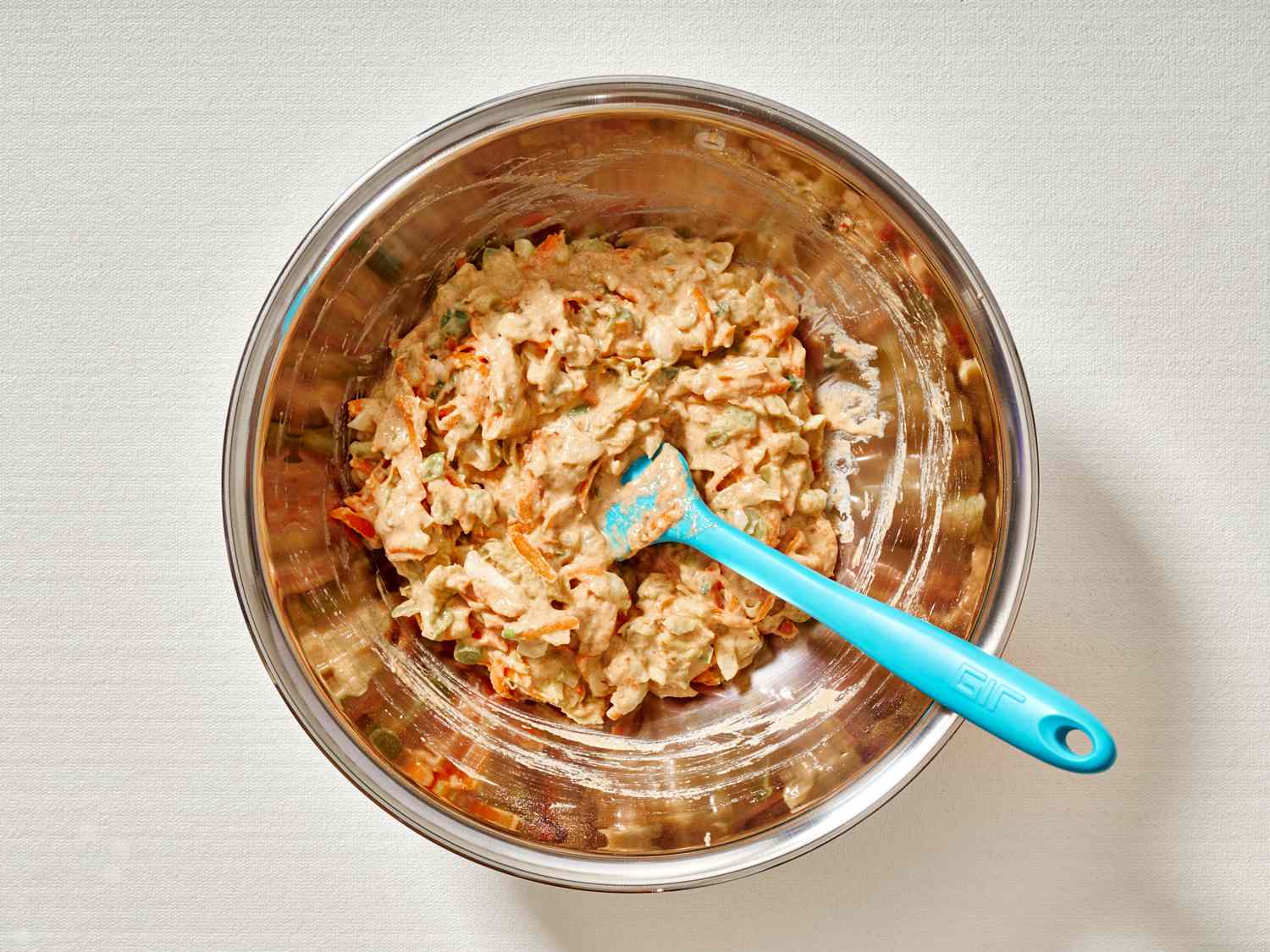Folding shredded vegetables into pancake batter.