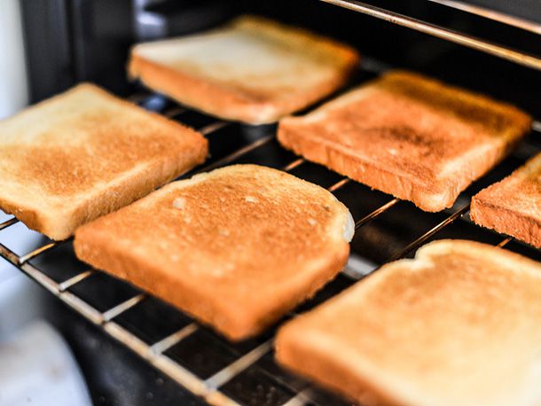 Slices of toasted white bread resting on a pulled out oven rack.