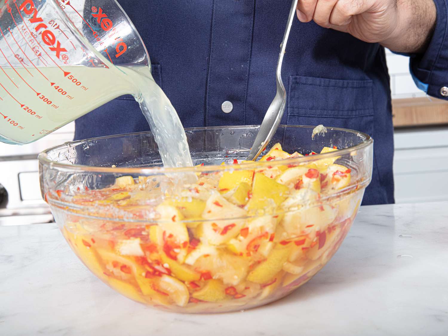 Overhead view of adding lemonade to lemons and chiles