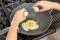 An egg is cooked in the Misen 12 Inch Carbon Steel Wok
