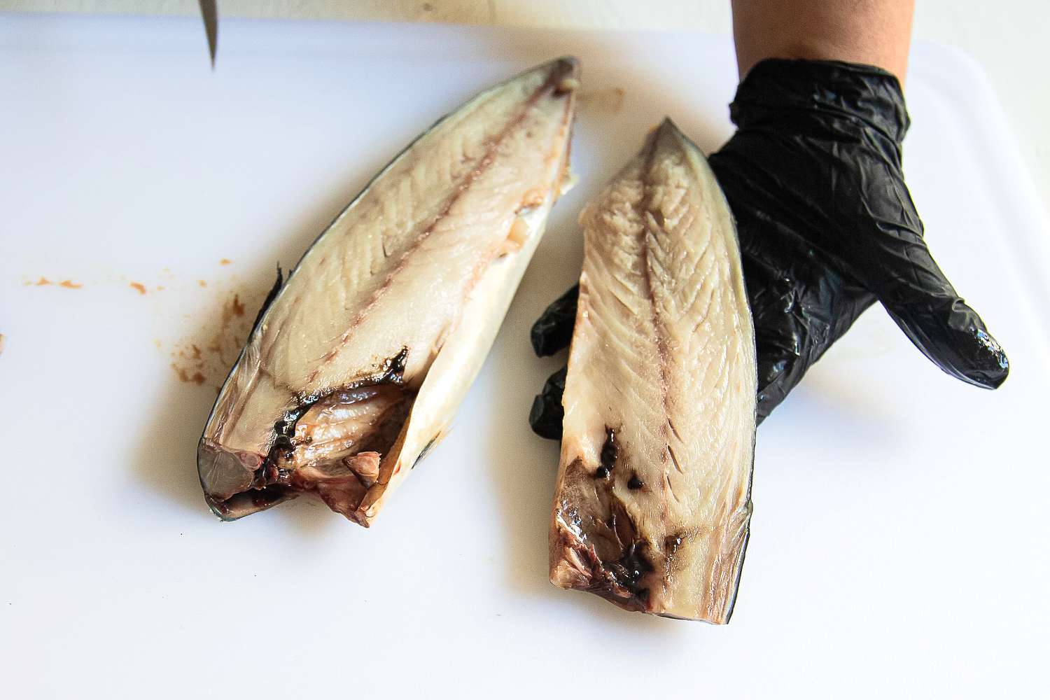 A person holding a slice of fish after being cut with the Victorinox Fillet Knife