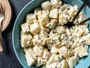Overhead view of classic potato salad served in a light blue bowl.