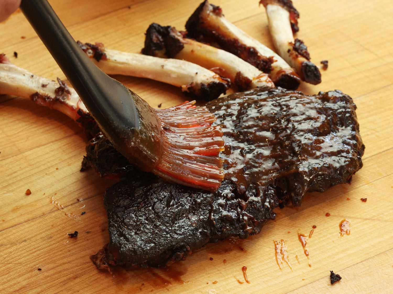 Basting a cooked rib with barbecue sauce, with the rib bones pulled out.