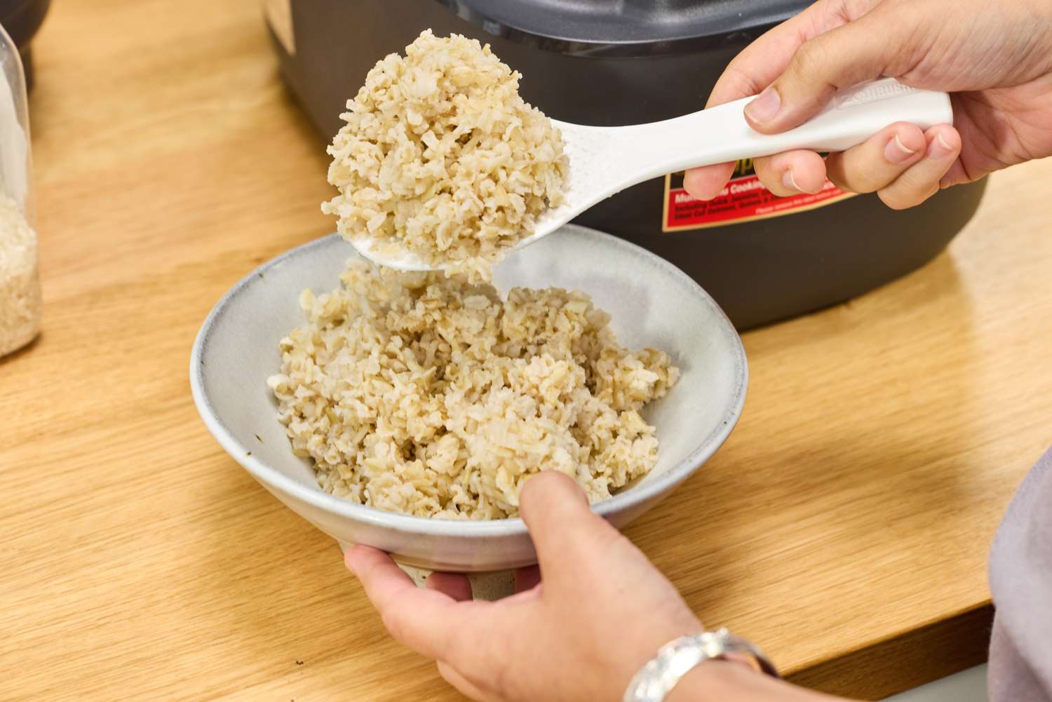 A person spoons rice cooked in the Zojirushi NW-QAC10 Induction Heating Rice Cooker & Warmer into a bowl