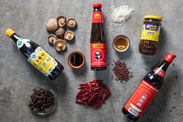 Overhead shot of Chinese culinary ingredients like sauce, mushrooms, and chilies