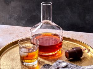 spiced rum in a glass with a decanter filled with the full batch