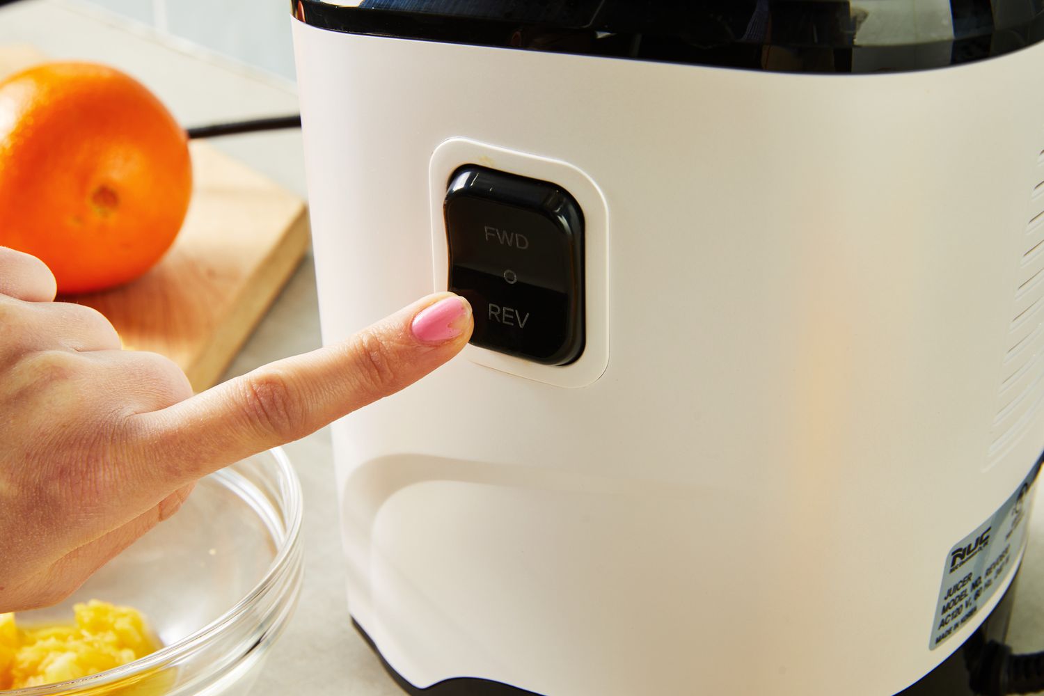 Person pressing the button on a Kuvings REVO830 Whole Slow Juicer