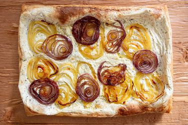 Baked tart with caramelized onion layers on a creamy base