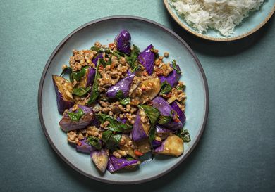 Overhead view of eggplant stir-fry plated on a blue plate on a blue background