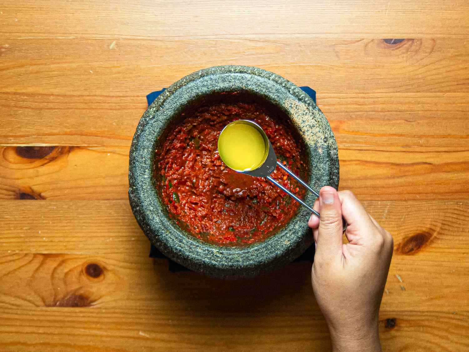 Overhead view of adding more lemon juice to mortar