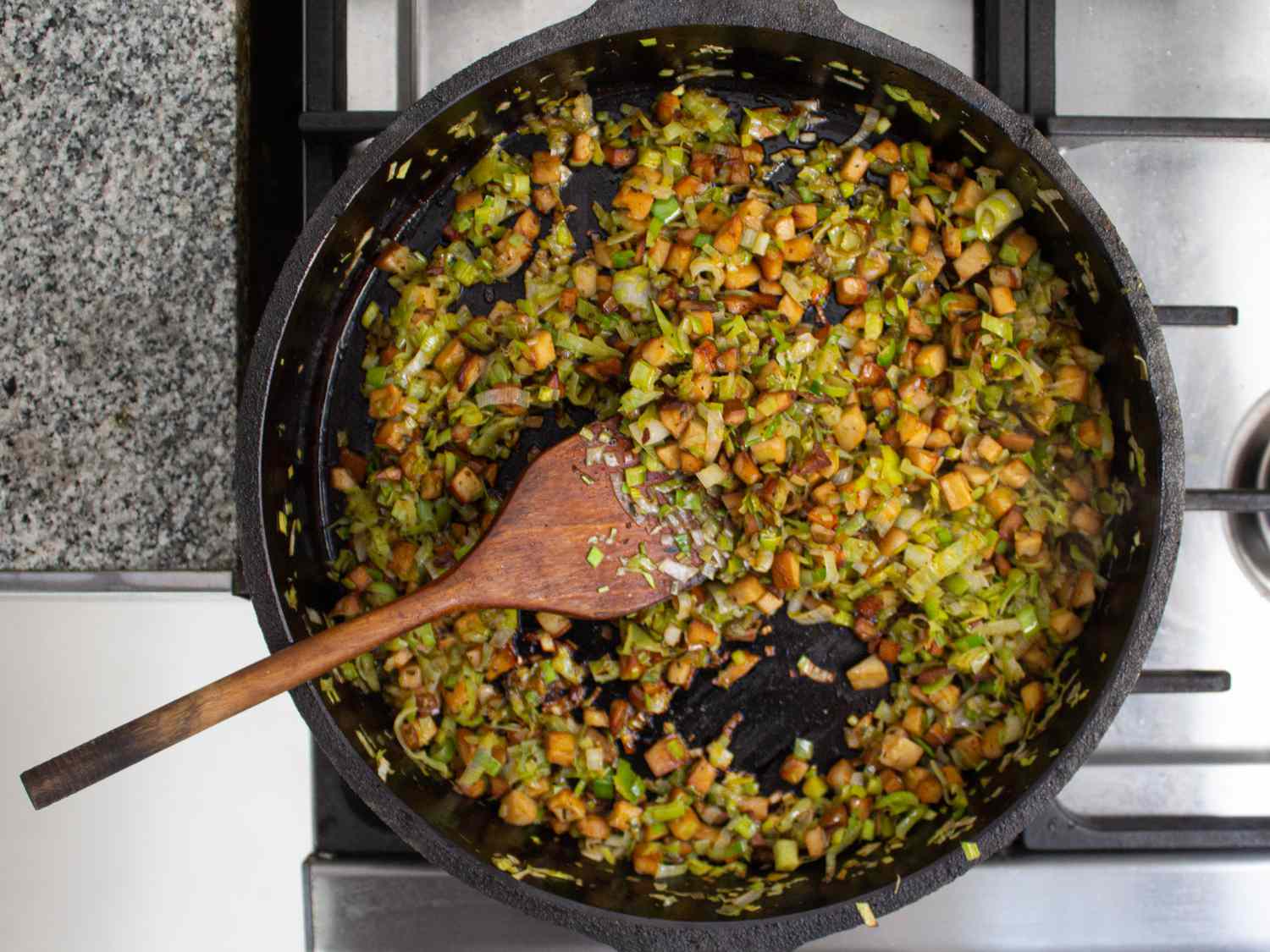 Overhead view of leeks cooking down with mushrooms