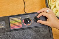 A person rotating the knob of Excalibur Electric Food Dehydrator Machine