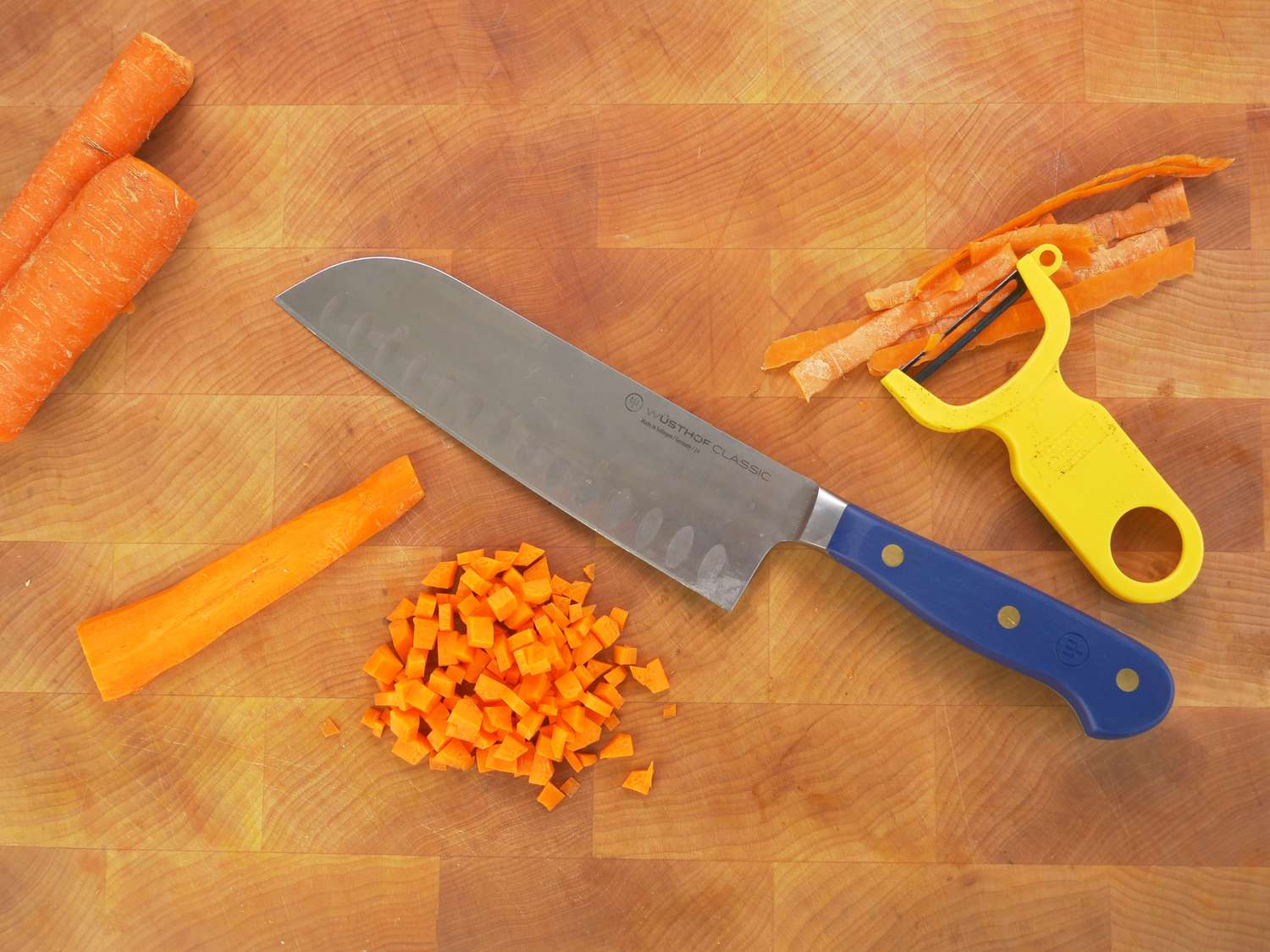 wusthof santoku knife on a wooden cutting board with a chopped carrot