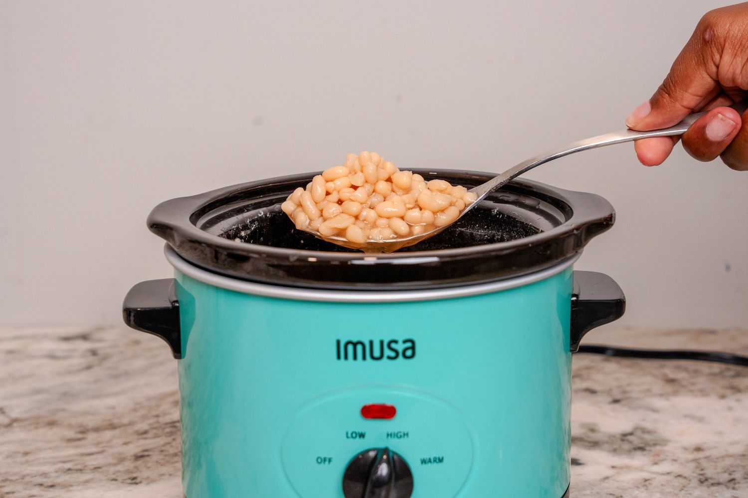 IMUSA 1.5 Quart Slow Cooker beans being scooped out