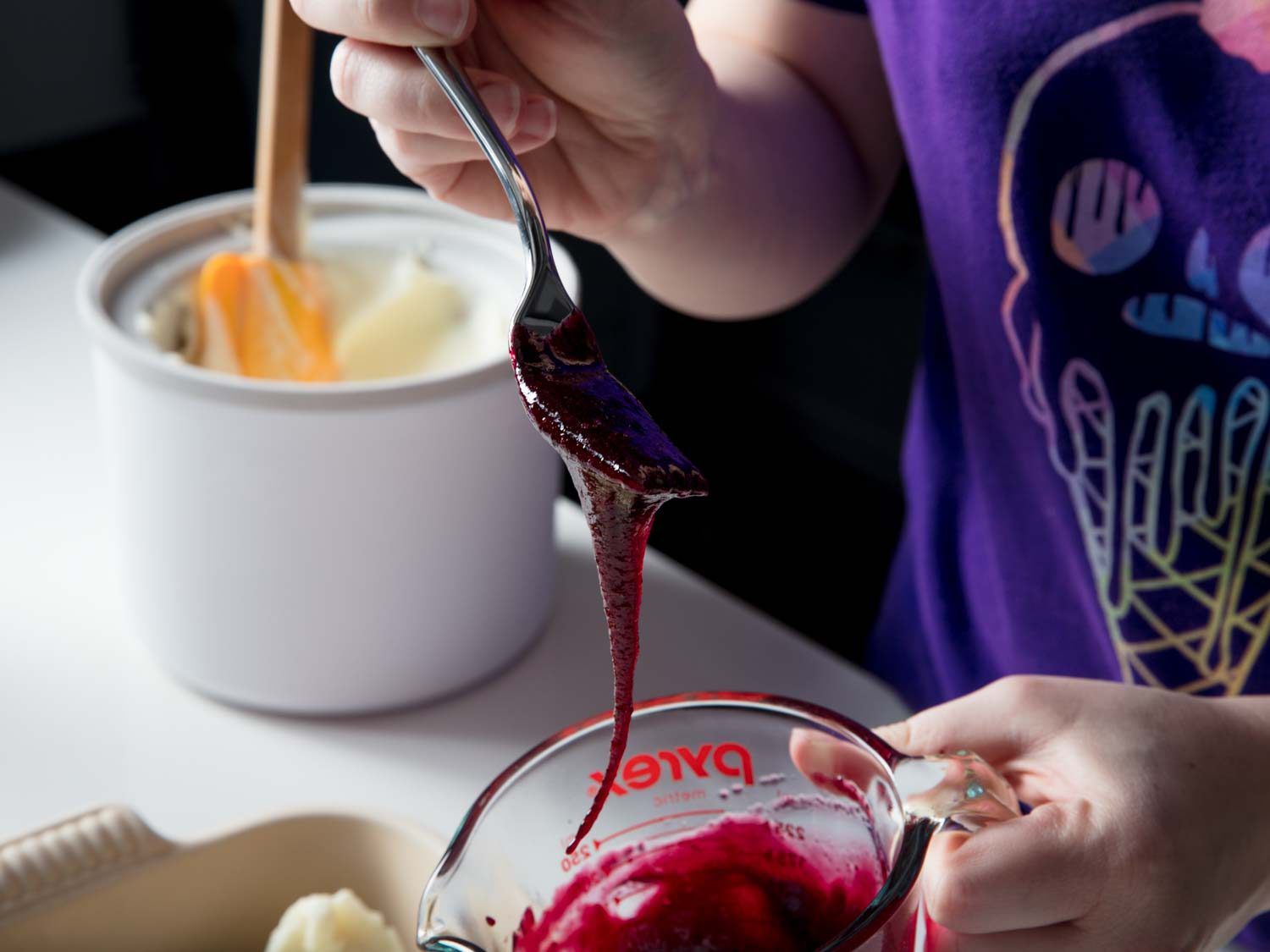 Spooning the syrup and let it drip into the measuring cup to demonstrate its viscosity.