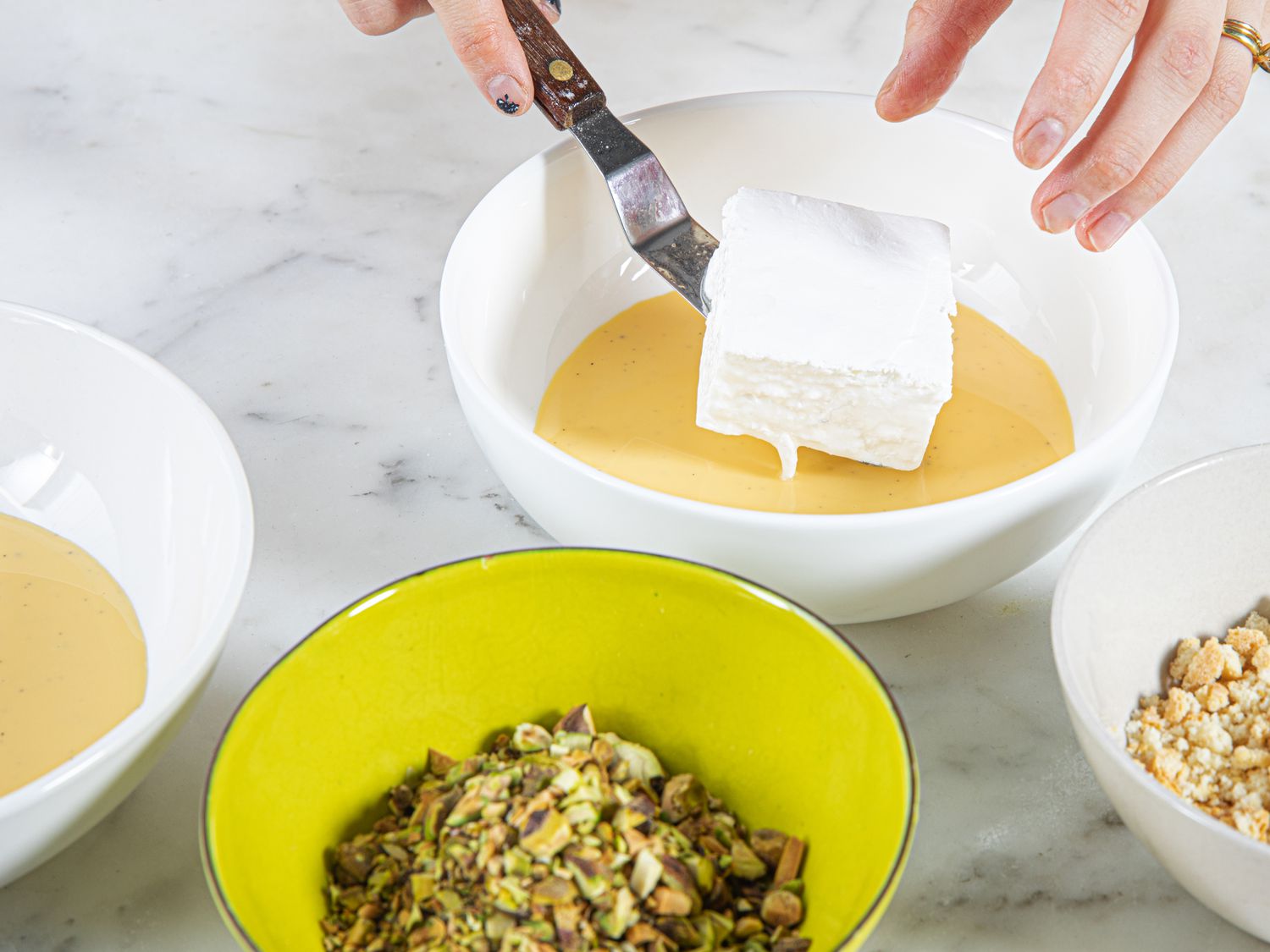 Overhead view of placing baked meringue into creme anglaise 