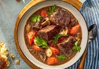 A bowl of beef bourguignon with big chunks of juicy beef, plump carrots, mushrooms and more.
