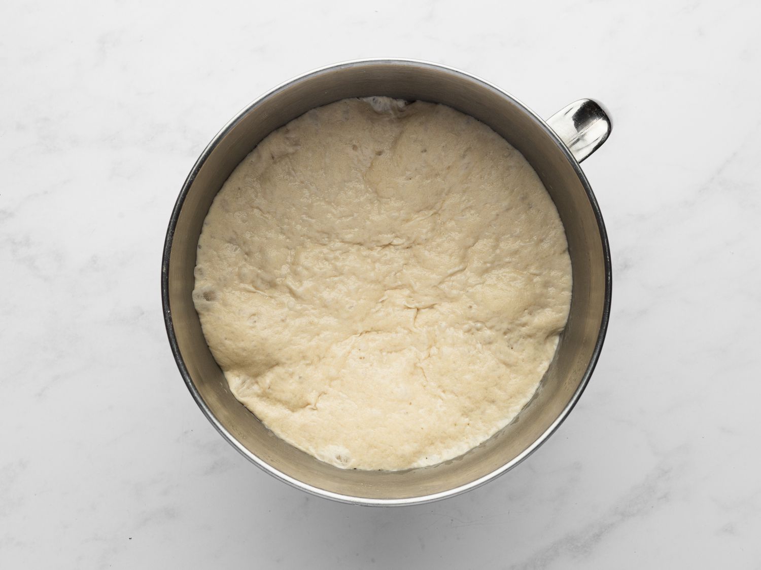 Overhead view of dough in bowl after it has rested