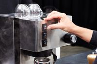 Closeup of a hand pushing a button on the Rancilio Silvia Espresso Machine 