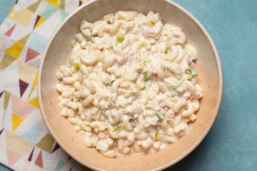 Overhead view of a bowl of tangy and creamy macaroni salad, served in a shallow bowl.
