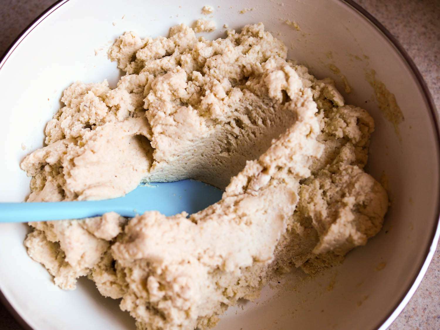 The masa-stock mixture being stirred with a spatula.