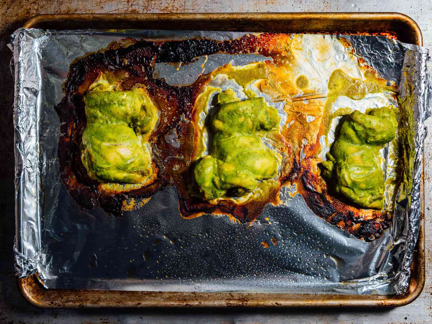 Overhead view of the sheet pan of gently roasted chicken thighs, fresh from the oven.