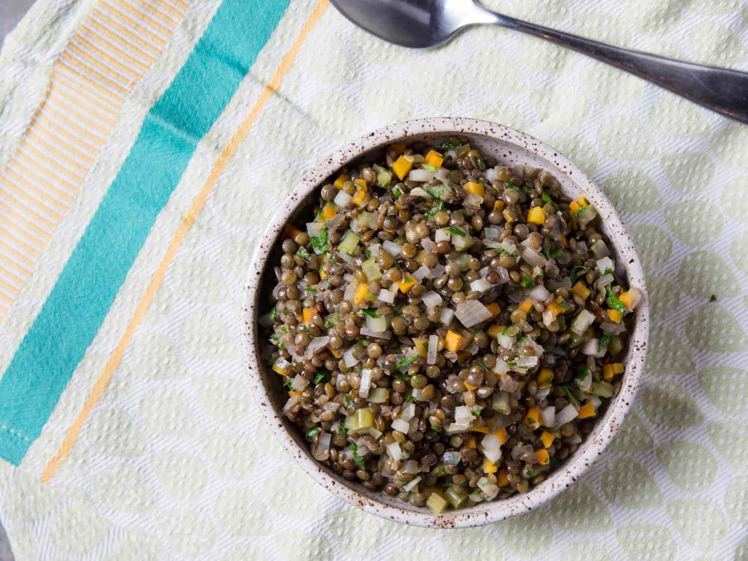 A bowl of simply-prepared French lentils with sauteed aromatics.
