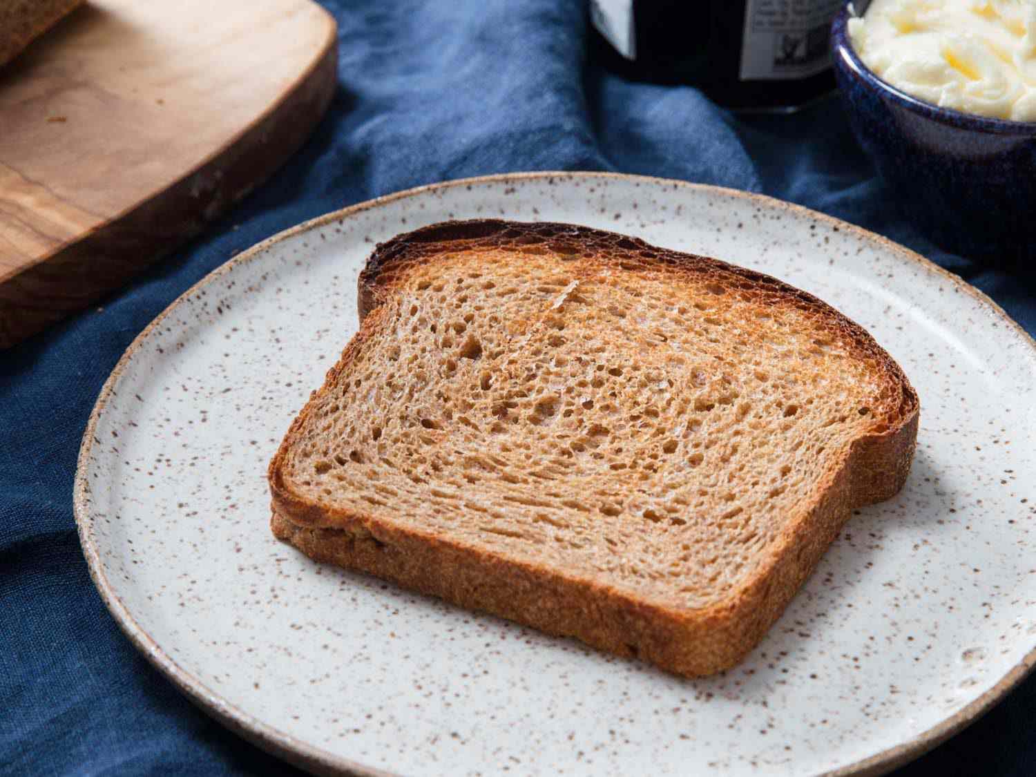 A slice of 100% whole wheat bread on a plate.