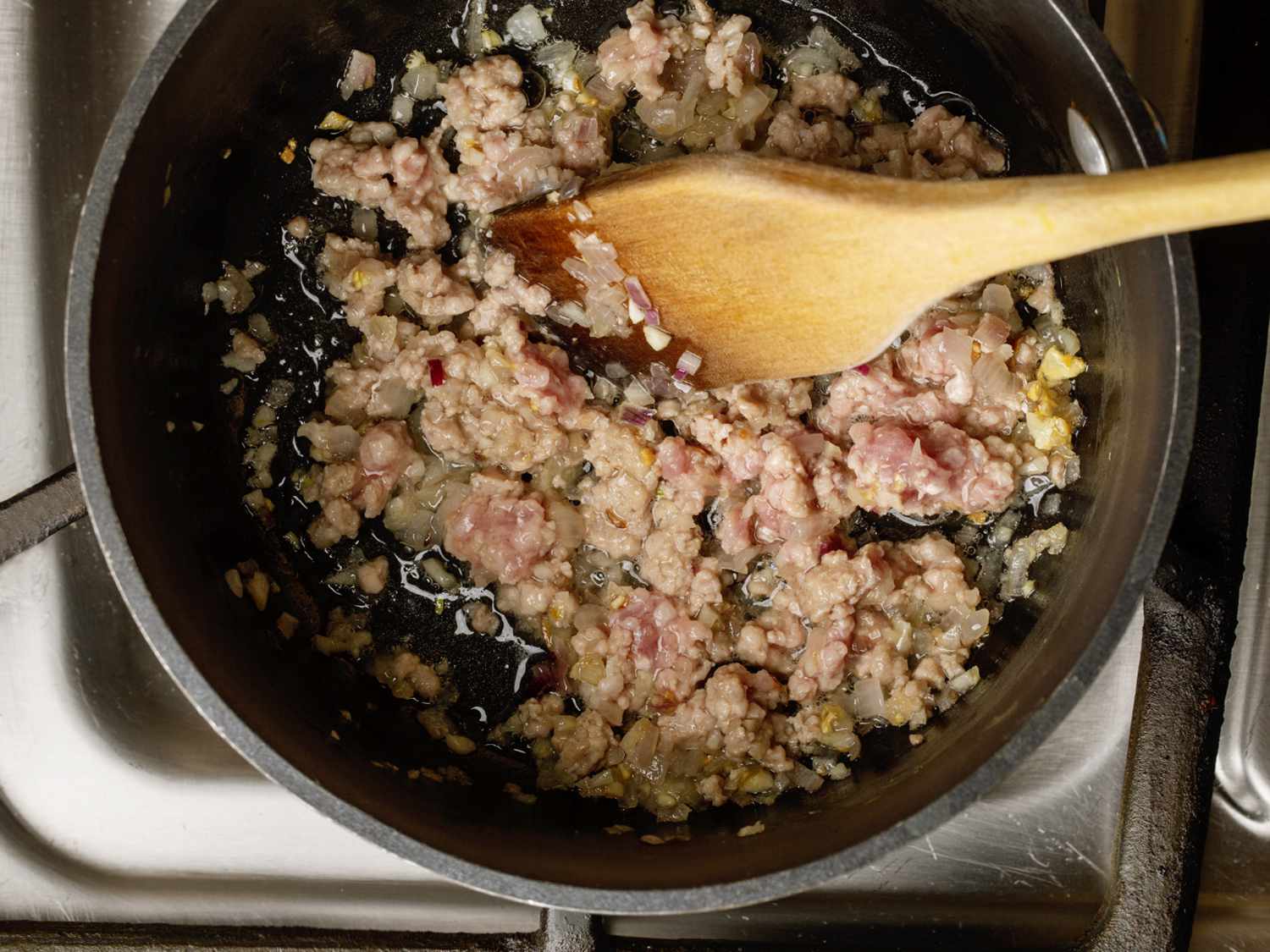 ground pork, garlic, and shallots being fried together in a saucepan