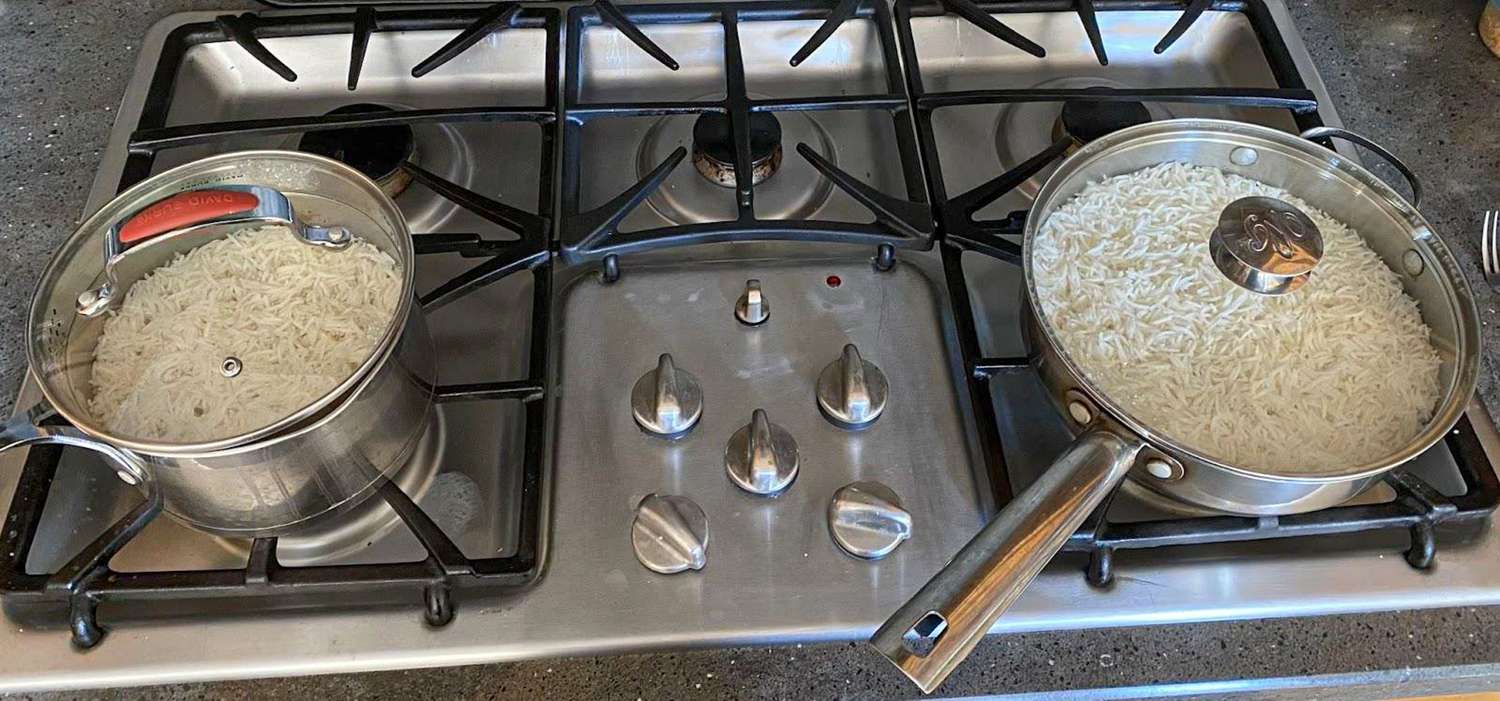 Two pots of cooked rice on a stovetop