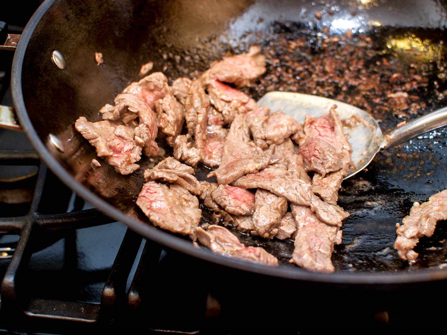 Beef slices cooking in a hot wok. 