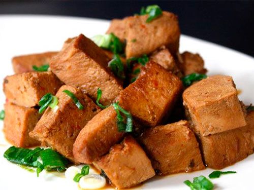 A plate of frozen tofu braised in soy sauce. 