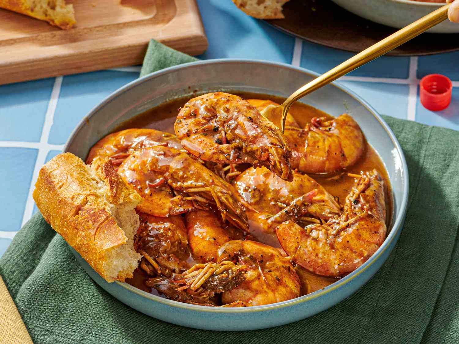 Bowl of New Orleansstyle BBQ shrimp with bread for dipping