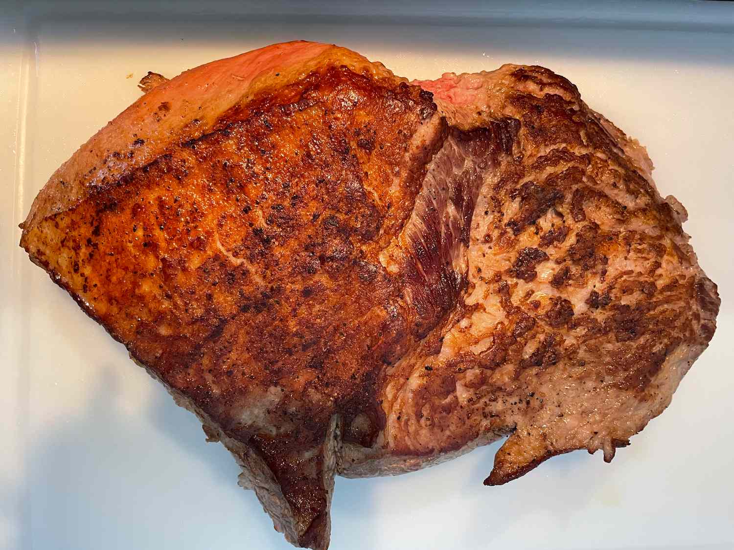 Cooked piece of meat on a white surface