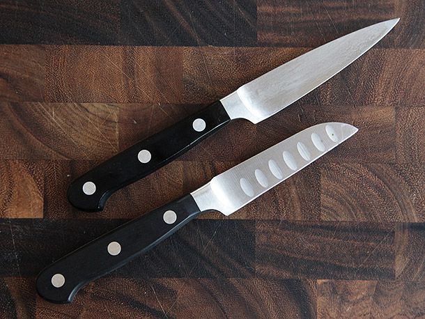 Wüsthof Classic 3 1/2-Inch Paring Knife and Wüsthof Classic 3-Inch Hollow Ground Paring Knife on wooden cutting board 