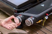 A person adjusts a dial on the Weber Slate 22 inch Rust-Resistant Tabletop Griddle