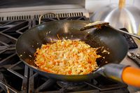 Food cooking in the Yosukata Carbon Steel Wok Pan on a gas stove 