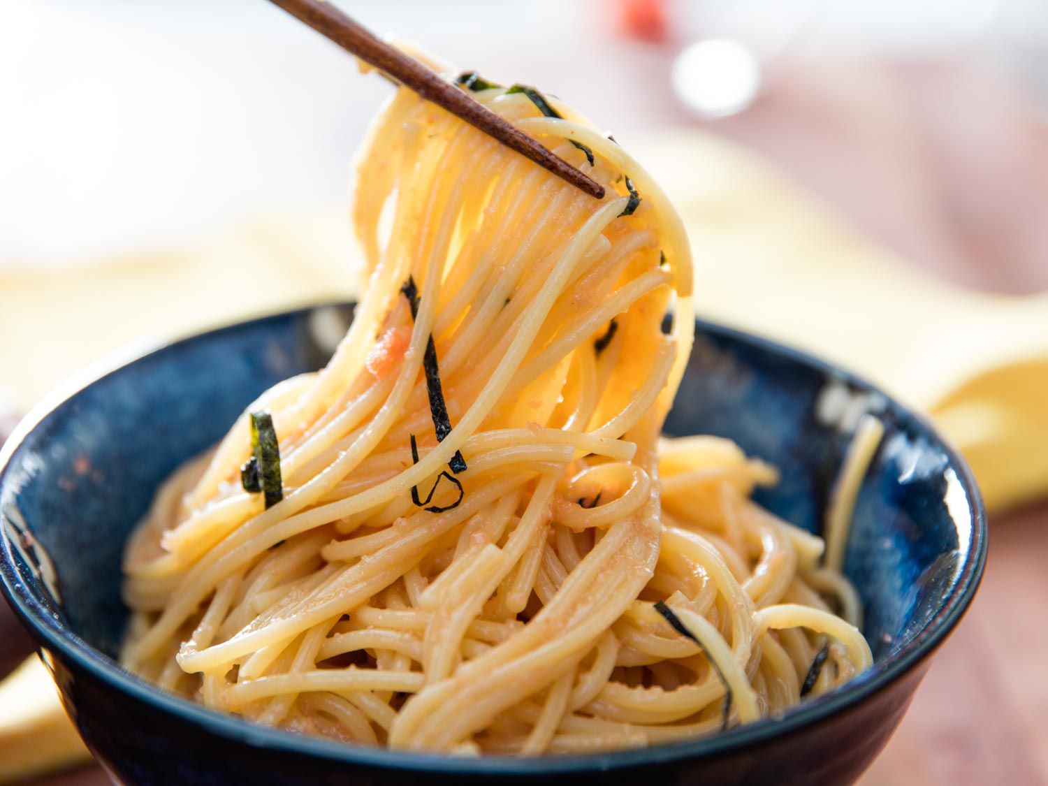 Mentaiko spaghetti being lifted from a serving bowl with chopsticks.