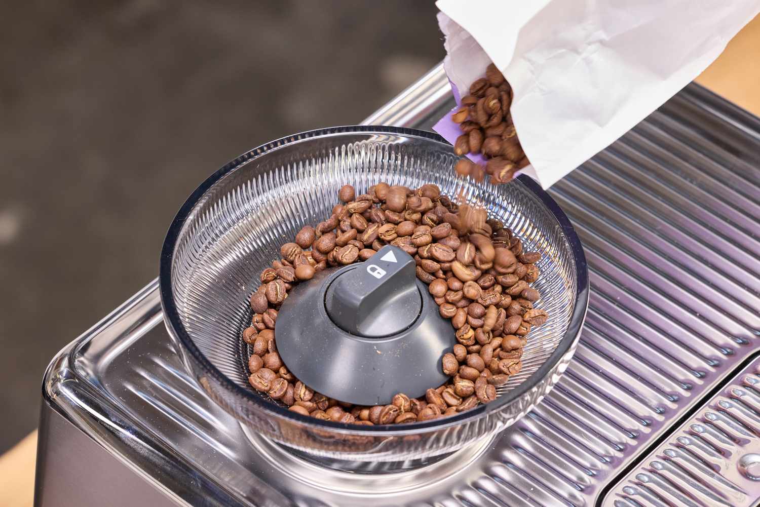 Espresso beans are poured into the Breville The Oracle Dual Boiler Espresso Machine grinder