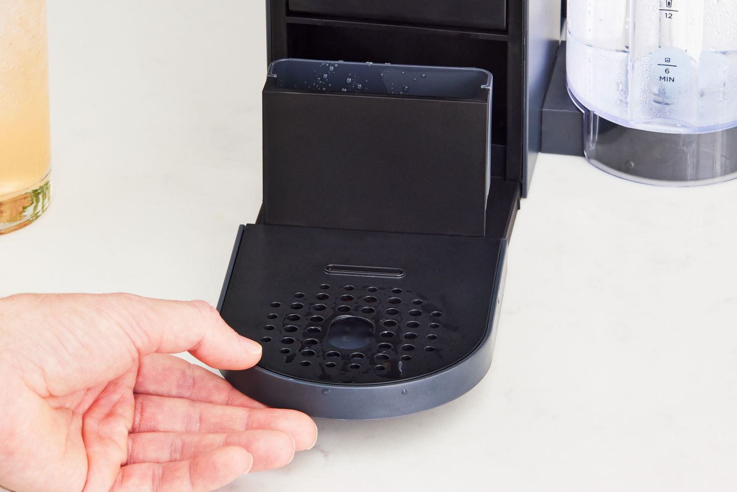 A hand removing the stand on the Ninja Thirsti Drink System