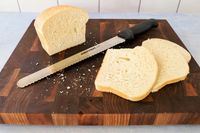 Dexter-Russell Basics 10-Inch Bread Knife With Black Polypropylene Handle in between sliced bread