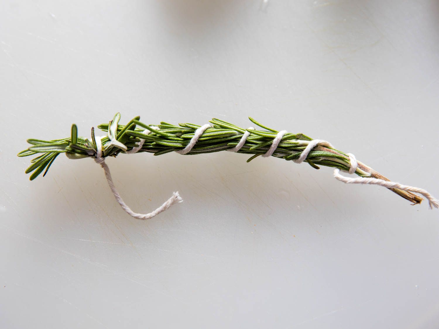 Tying up rosemary and thyme with kitchen twine is one way to keep their leaves from ending up scattered throughout the pot.