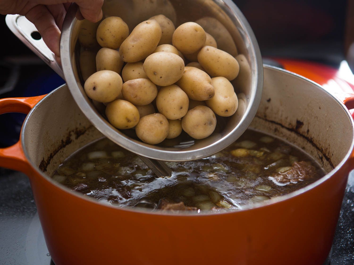 Adding baby Yukon Gold potatoes to simmering beef stew
