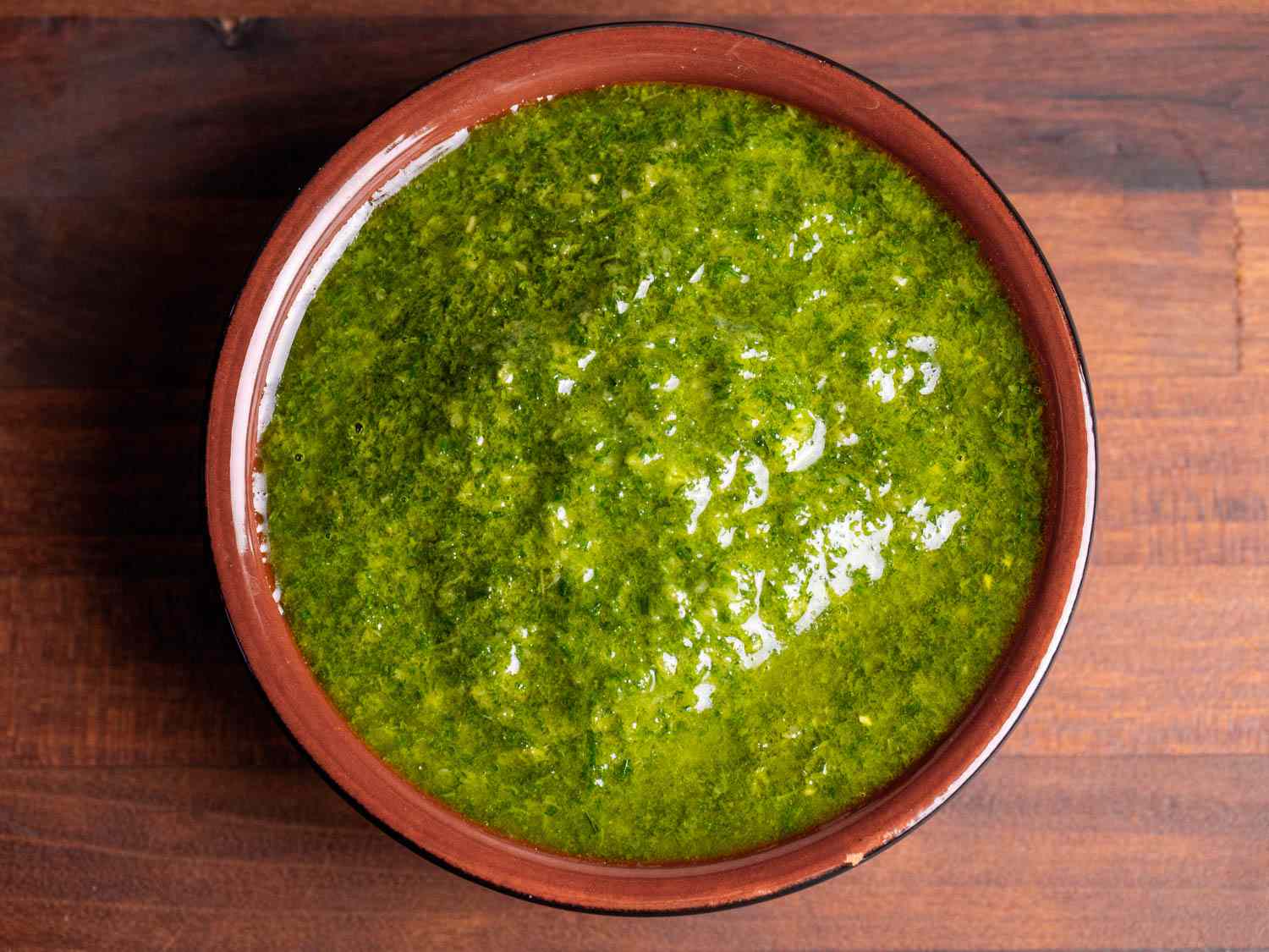 A small dish filled with bright green fennel frond pesto