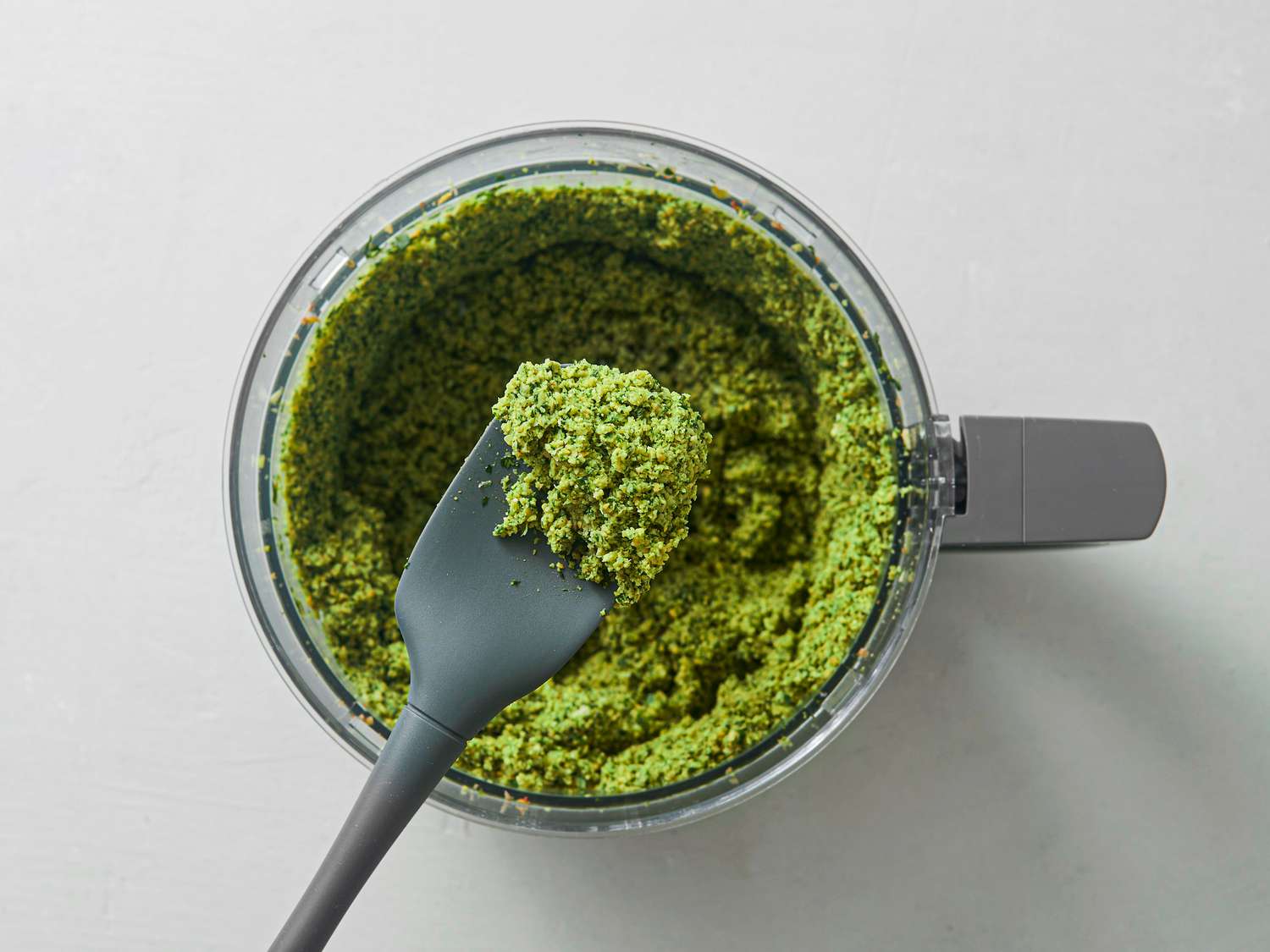 Chickpeas, herbs, scallions, garlic, cumin, coriander, and salt pulsed until chickpeas are very finely minced inside food processor bowl.