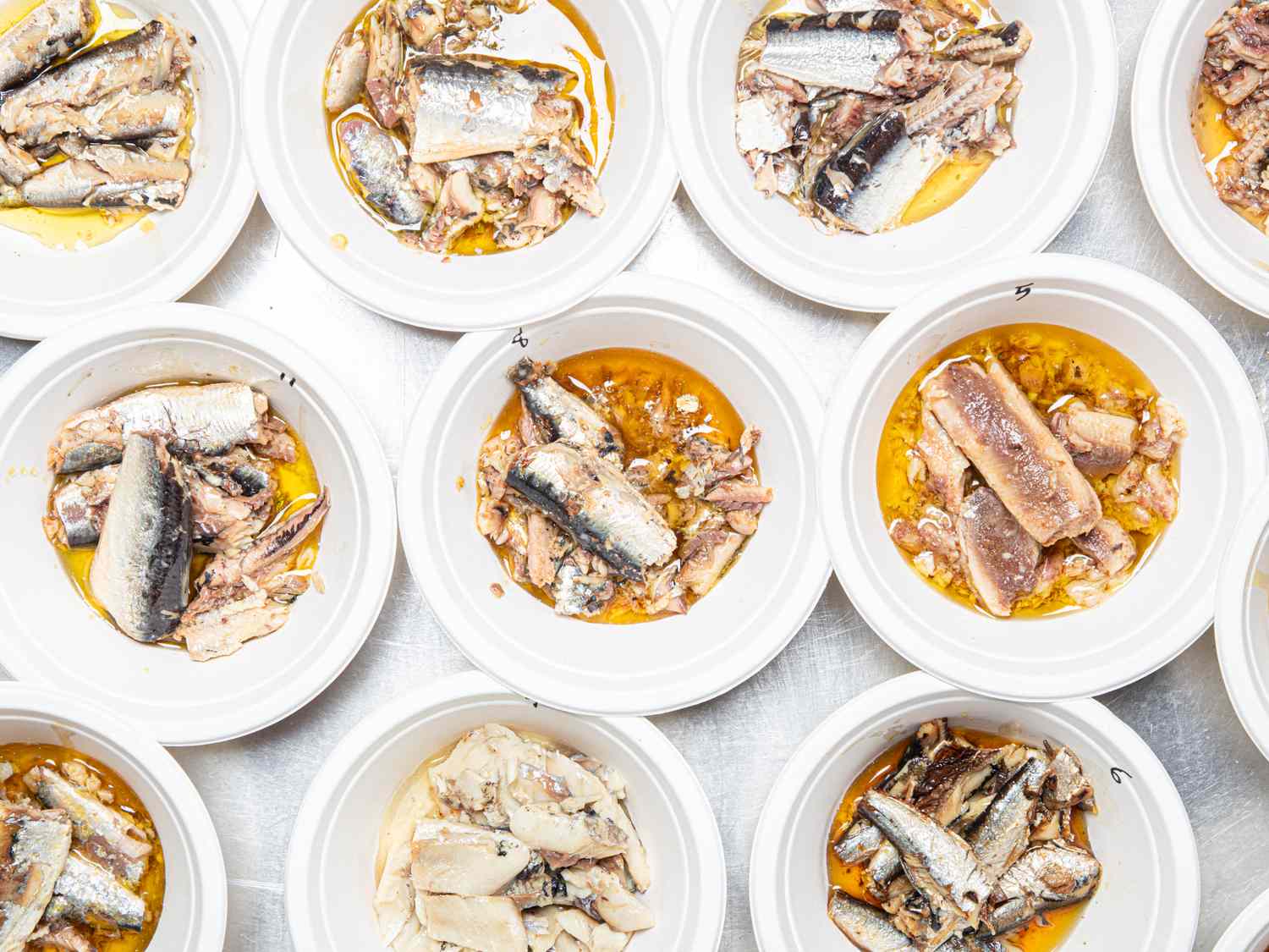 Multiple bowls containing tinned sardines shown in various presentations